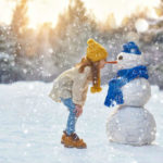 雪景色の中の雪ダルマと女の子