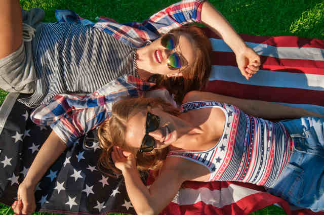 アメリカ国旗で寝る女性